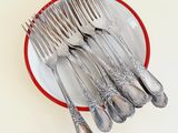 a lot of silverware on a red and white plate
