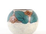 un vase blanc orné de fleurs bleues et orange
