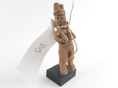 wooden figurine of a man holding a piece of paper on a stand