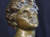 a close up of a bronze statue of a man with his head turned to the side