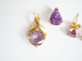 two pairs of amethe earrings and a pair of amethe earrings on a white surface