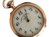 a gold pocket watch with roman numerals on the face