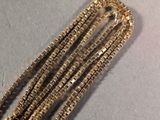 a close up of a gold chain with beads on it