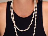 portrait d'une femme portant un collier de perles et un débardeur noir