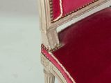 an upholstered chair with red velvet upholstered seat and gold trim