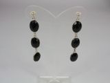 a pair of earrings with black stones hanging from them