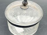 an antique silver plated box with a glass lid and a bird on top