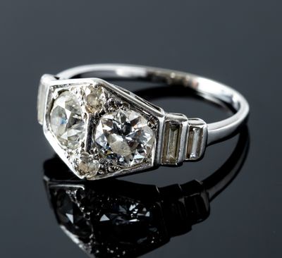 an old cut diamond ring on a black surface