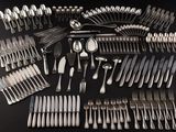 a large collection of silverware on a black table