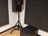 two speakers and a speaker stand in the corner of a room