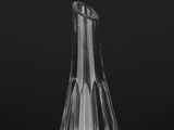 a clear glass vase sitting on top of a table next to a black background