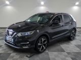 un SUV Nissan noir garé sur un sol à damier dans un garage