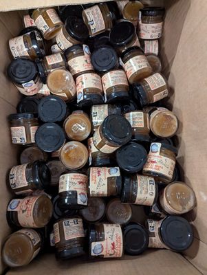 une boîte en carton remplie de bocaux contenant différentes sortes de sauces