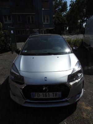 a silver car parked in a parking lot next to a white car