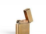 a gold lighter that is sitting on a white surface