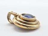 an image of a close up of a gold ring with a blue stone