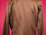 brown jacket on a mannequin stand against a red background