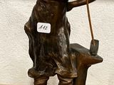 figurine en bronze représentant une femme avec un chien, posée sur un socle