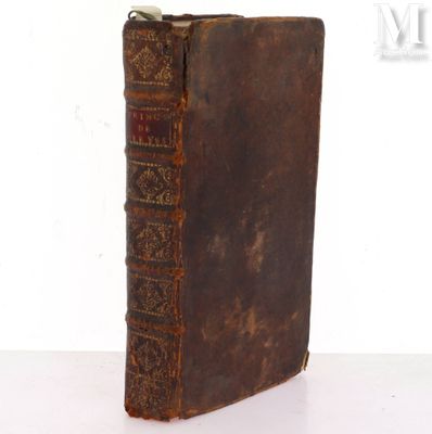 an old book sitting on top of a table next to a white wall