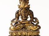 a gold statue of a woman sitting on a lotus