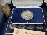 a silver coin sitting in a blue box with a card
