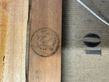 a piece of wood with a stamp on it next to a piece of wood