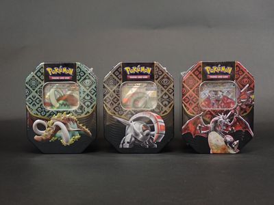 trois types différents de cartes à collectionner Pokémon dans une vitrine