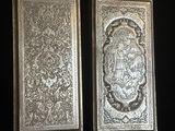 deux plaques métalliques argentées sur fond noir, l'une représentant un lion et l'autre un lion