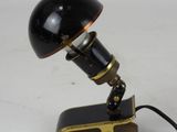 an image of a black lamp with a gold base on a white surface
