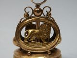 an antique brass clock with a lion on top of it