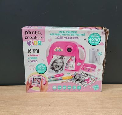 a pink toy camera sitting on top of a wooden table