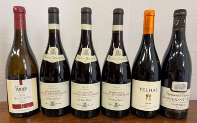 six bottles of wine are lined up on a wooden table