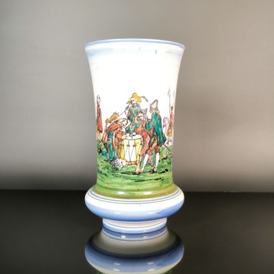 a vase with a painting on it sitting on a table