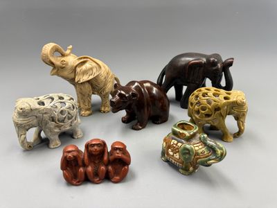 plusieurs figurines d'éléphants de différentes couleurs posées sur une surface grise
