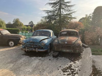 deux vieilles voitures garées l'une à côté de l'autre sur le bord de la route