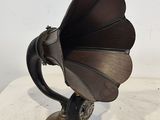un vieux gramophone posé sur une table, sur fond blanc