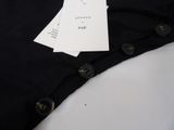 a black shirt with a tag on it sitting on a table