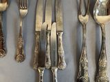 a lot of silverware on a table with spoons and forks