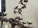 une sculpture métallique représentant un oiseau posée sur une commode