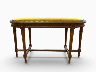 an old wooden bench with a yellow cushion on top of it