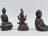 three bronze statues of buddhas sitting on top of a table