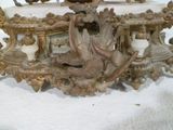 une grande horloge posée sur une table et surmontée d'un oiseau