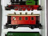 trois petits trains miniatures posés dans une boîte sur une table