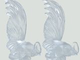 deux figurines en verre transparent représentant des oiseaux sur fond blanc