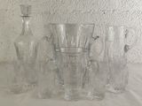 bottles and glasses are lined up on a table in front of a wall