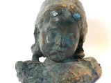 statue représentant une femme assise sur un rocher, la tête posée sur ses mains