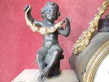 a small statue of a boy sitting on a clock