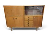 une armoire en bois à trois tiroirs et une porte vitrée