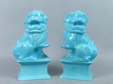 paire de statuettes « foo foo » émaillées de bleu, posées sur des socles, sur fond gris