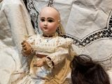 a doll that is sitting on a bed next to a doll
